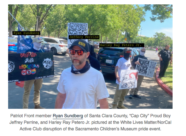 A group of masked nazis stand with signs outside the Sacremento Children's Museum. Perrine is unmasked. The caption reads, "Patriot Front member Ryan Sundberg of Santa Clara County, Cap City Proud Boy Jeffrey Perrine, and Harley Ray Petero Jr pictured at the White Lives Matter / NorCal Active Club disruption of the Sacremento Children's Museum pride event."