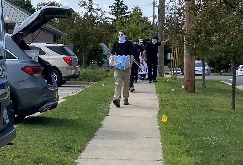 A shot of the neo-nazis returning to their vehicles, and supplies being loaded into Brandon’s car.