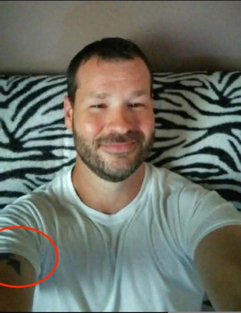 selfie of michael lee francis showing his tattoo on a zebra fabric couch wtf